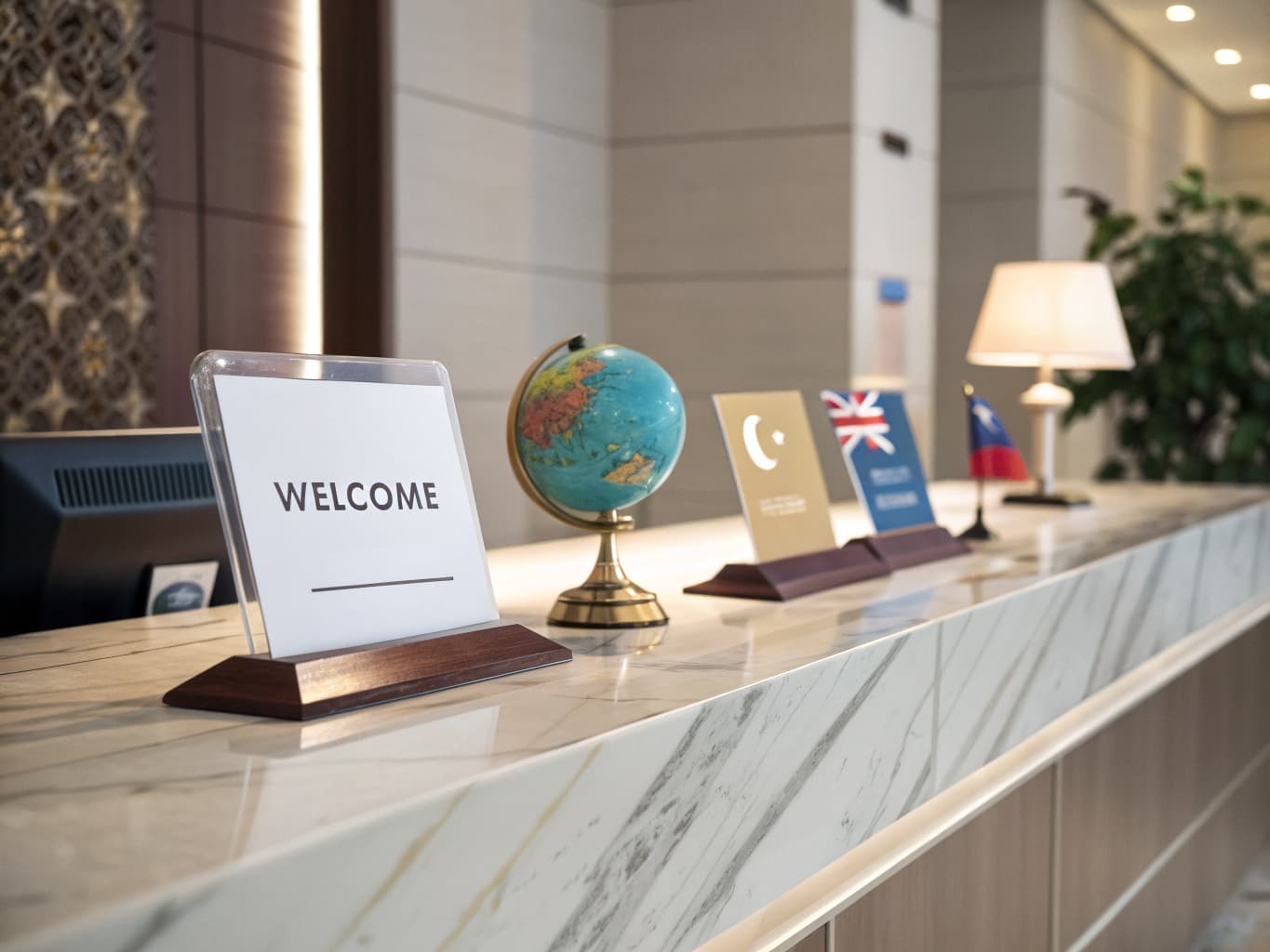 Welcome sign and globe with international flags on a hotel reception desk