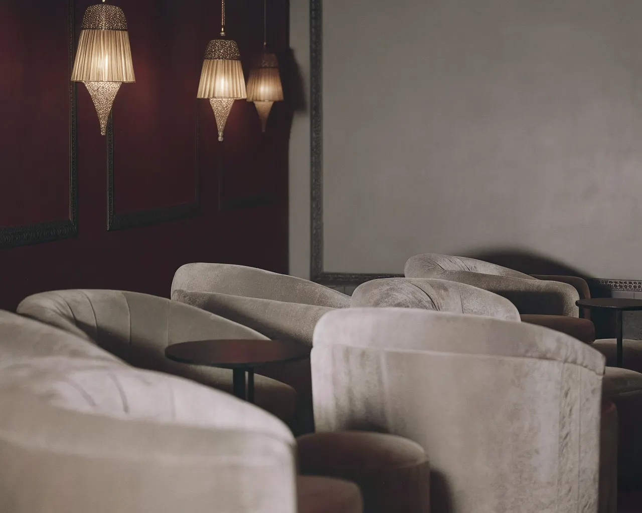 Elegant lounge seating area with velvet armchairs and warm amber pendant lighting