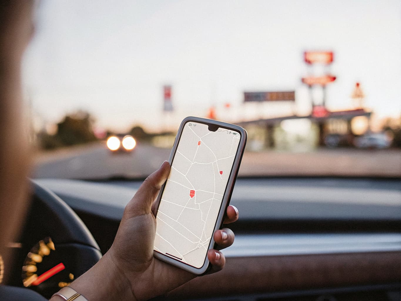 Traveler searching for a nearby motel on a smartphone from the car at night