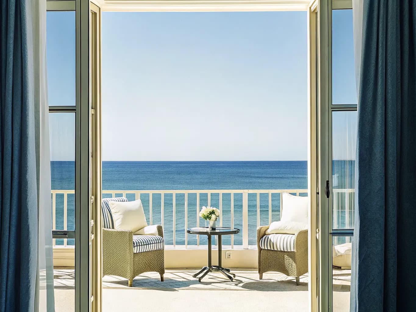 Luxurious resort suite balcony with ocean view and plush furnishings